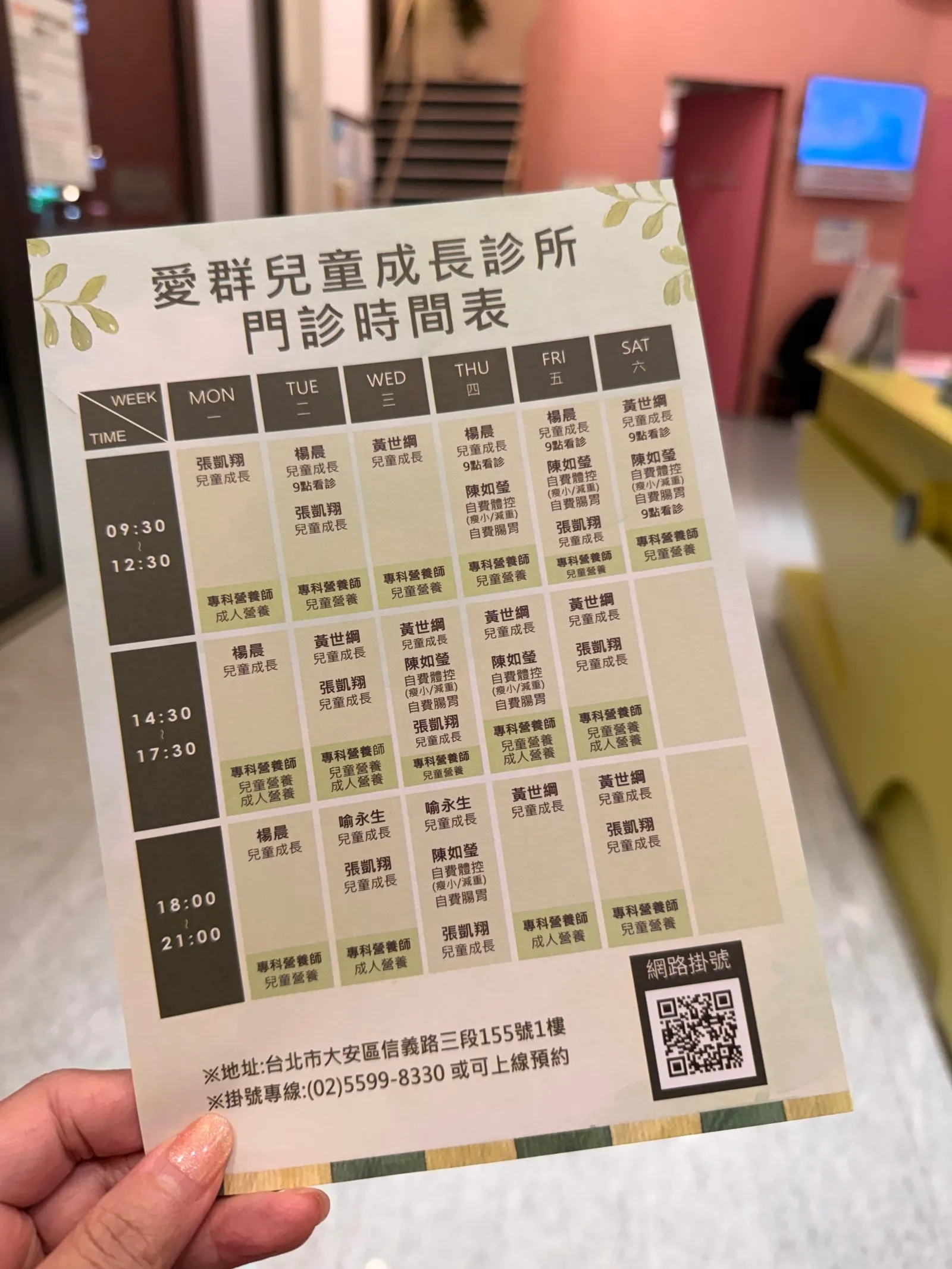 愛群兒童成長診所的門診時間表,列出各醫師在週一到週六三個時段的看診安排,右下角有網路掛號 QR code